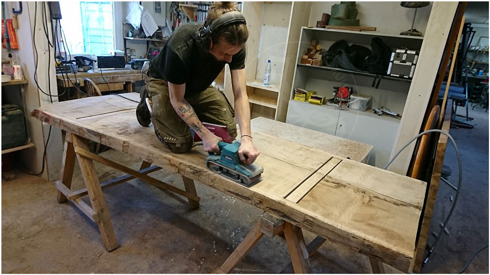 Ein Schreiner der Krebsmühle schleift einen Tisch